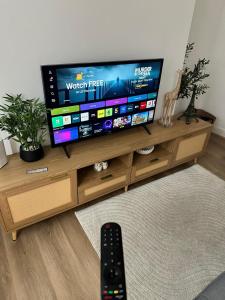a flat screen tv sitting on top of a wooden entertainment center at 3 Bed Near Coventry Arena, Contractor & Family Accommodation in Coventry