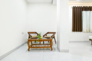 a living room with two chairs and a table at FabHotel Rama in Indore