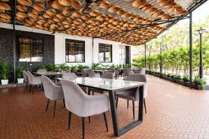 a dining room with tables and chairs and windows at FabHotel Rama in Indore