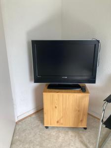 a flat screen tv sitting on top of a wooden stand at Self check in ganzes Apartment 40 m zwei Schlafzimmer Wlan Parkplatz eigenes Badezimmer mit Badewanne Kochecke Einfamilienhaus in Duisburg +4 photos