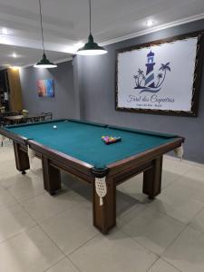 a pool table in a room with a sign at Farol dos Coqueiros in Angra dos Reis