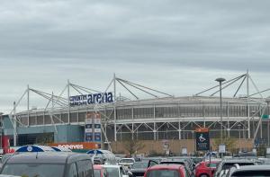 a large stadium with cars parked in front of it at 3 Bed Near Coventry Arena, Contractor & Family Accommodation in Coventry