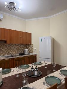 a kitchen with a table with wine glasses and a refrigerator at Shiroke Relax Villa in Shirokë +9 photos