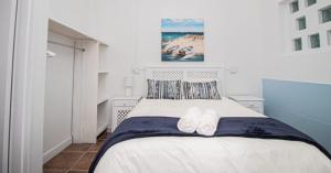a bedroom with a bed with two towels on it at EBB Tide Guesthouse in Velddrif