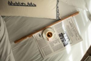 a newspaper and a cup of coffee sitting on a bed at Ergon House Ermou in Athens +64 photos