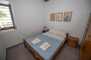 a bedroom with a bed with two white towels on it at Aegean Dream in Klíma
