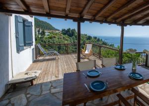 a wooden deck with a table and chairs on a balcony at Aegean Dream in Klíma