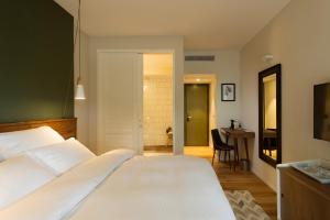 a bedroom with a large white bed and a bathroom at NEA Resort & People in Shave Ẕiyyon
