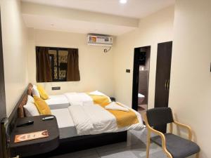 a bedroom with a bed and a chair in it at Hotel SK Chakan Pune in Dehu +35 photos