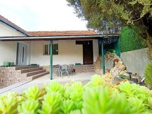 a house with a patio with a table and chairs at Kuca Denic in Svrljig +9 photos