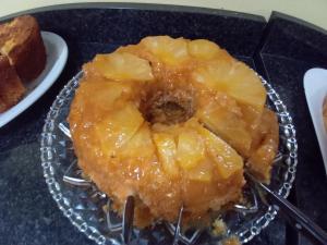 a piece of cake with pineapple on a glass plate at Pousada São Benedito CP in Cachoeira Paulista