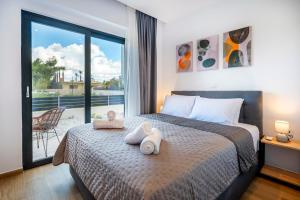 a bedroom with a bed with two towels on it at Odaria Premium Apartments in Lampi