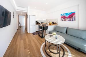 a living room with a blue couch and a table at Odaria Premium Apartments in Lampi