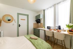 a bedroom with a bed and a kitchen with a counter at Le Sauge - Studio climatisé - Cocon rénové in Agen +4 photos