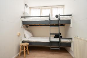 two bunk beds in a room with a window at Theislandlife 10p Centrum Texel in Den Burg