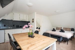 a kitchen and dining room with a table with flowers on it at Theislandlife 10p Centrum Texel in Den Burg
