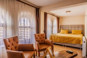 a bedroom with a bed and two chairs and a table at Ayaz Stone House in Göreme +105 photos