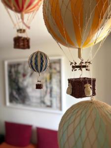 a group of hot air balloons hanging from a ceiling at COMO mi CASA in Malgrate