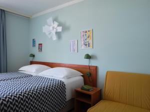 a bedroom with a bed and a chair and a cross on the wall at Amadria Park Beach Hotel Niko in Šibenik +27 photos