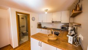 a kitchen with white cabinets and a wooden counter top at Gästehaus Holzer Kreuz - Ferienwohnung "Mohn" in Fröhnd
