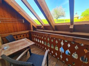 a balcony with a table and chairs and a window at Gästehaus Holzer Kreuz - Ferienwohnung "Mohn" in Fröhnd +12 photos
