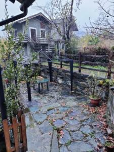 a stone patio with a bench in front of a house at The Golden Eagle - Champdepraz in Champdepraz