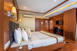 a hotel room with a large bed and a television at Hotel Sawood International in Kolkata +289 photos