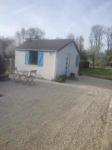 a white house with a table in front of it at Le 13 au vert in Montigny-les-Monts