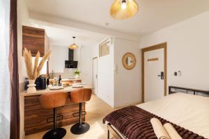 a bedroom with a bed and a desk with two chairs at Le Brun - T1 climatisé - Terrasse et jardin privé in Agen