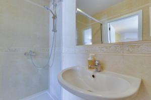 a bathroom with a sink and a shower with a mirror at Nice double bedroom in beautiful Quinta - QR06 in Lagos +22 photos