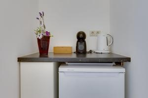 a table with a coffee maker and flowers on it at Nice double bedroom in beautiful Quinta - QR06 in Lagos