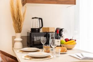 a kitchen counter with a table with plates and wine glasses at Le Brun - T1 climatisé - Terrasse et jardin privé in Agen +4 photos