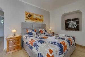 a bedroom with a bed with a colorful comforter at Great double bedroom in beautiful Quinta - QR07 in Lagos +25 photos