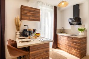 a kitchen with wooden cabinets and a table with food on it at Le Brun - T1 climatisé - Terrasse et jardin privé in Agen