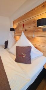 a bed with white sheets and a pillow on it at Gästehaus Holzer Kreuz - Ferienwohnung "Narzisse" in Fröhnd