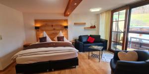 a bedroom with a large bed and two chairs at Gästehaus Holzer Kreuz - Ferienwohnung "Narzisse" in Fröhnd