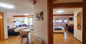 a hotel room with two beds and a desk and a bedroom at Gästehaus Holzer Kreuz - Ferienwohnung "Narzisse" in Fröhnd