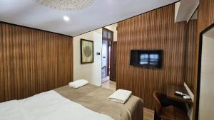 a bedroom with a bed and a tv on a wall at Konak 83 in Nicosia