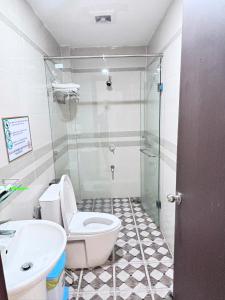a bathroom with a shower and a toilet and a sink at Sao Việt Nam Hotel in Ho Chi Minh City +3 photos