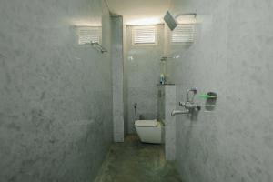 a white bathroom with a toilet and a shower at Regal Palace Hotel and Banquets in Patna