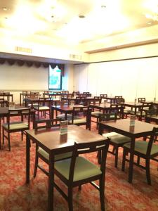 a room filled with tables and chairs and a screen at Hotel Crown Hills Yamagata in Yamagata