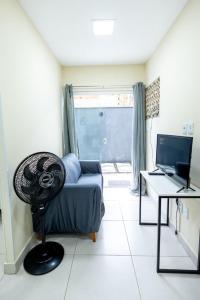 a room with a couch and a desk with a computer at Studio Completo c Wifi perto do Centro de Itabuna in Itabuna