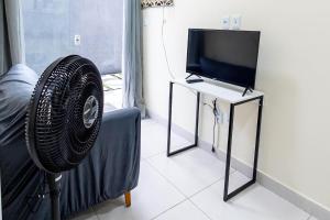 a living room with a flat screen tv and a fan at Studio Completo c Wifi perto do Centro de Itabuna in Itabuna