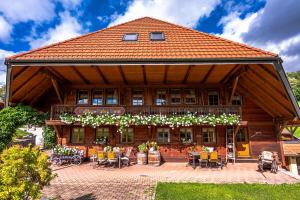 a building with tables and chairs in front of it at Gästehaus Holzer Kreuz- Gästezimmer Margerite für 2 Personen inkl Landfrühstück in Fröhnd