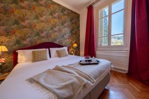 a bedroom with a large white bed with red curtains at Serristori Palace Residence in Florence