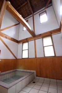 um quarto vazio com paredes e janelas brancas em Guest House Eleven Village Fukiya em Fukiya