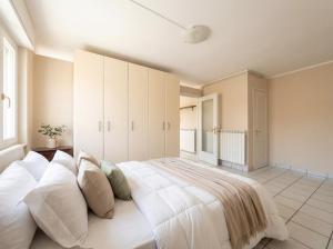 ein Schlafzimmer mit einem großen Bett mit weißen Laken und Kissen in der Unterkunft Central Duplex in Iseo - 2 Bedrooms - Private Parking & WiFi in Iseo