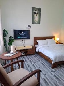 a bedroom with a bed and a tv and a table at G4 homez in Morogoro