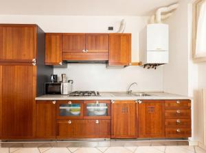 eine Küche mit Holzschränken und einer Spüle in der Unterkunft Central Duplex in Iseo - 2 Bedrooms - Private Parking & WiFi in Iseo + 6 Fotos