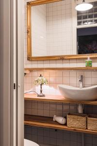 a bathroom with a sink and a mirror at Artist Apartment Susi in Helsinki